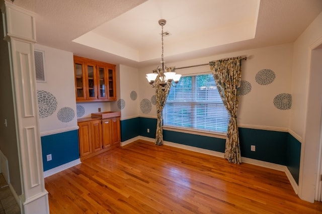 4509 W Highland Knolls Rd, Rogers, AR 72758 - unfurnished dining area with light wood-type flooring, a raised ceiling, a chandelier, and baseboards