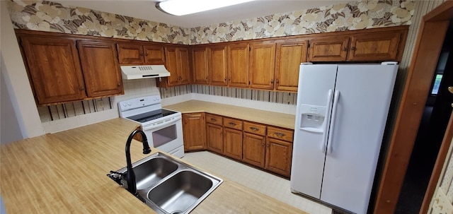 8 Mindy Ln, Bella Vista, AR 72715 - kitchen featuring white appliances, under cabinet range hood, a sink, light countertops, and brown cabinets