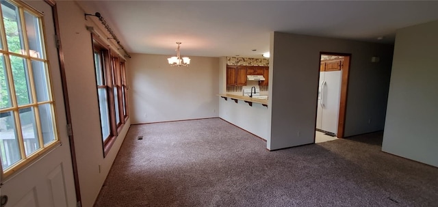 8 Mindy Ln, Bella Vista, AR 72715 - unfurnished living room with a chandelier, light colored carpet, plenty of natural light, and a sink
