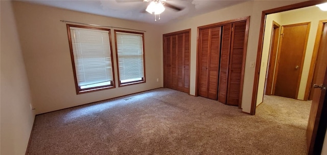 8 Mindy Ln, Bella Vista, AR 72715 - unfurnished bedroom featuring carpet floors, multiple closets, and a ceiling fan