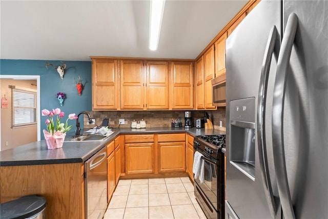 928 S Maple St, Siloam Springs, AR 72761 - kitchen with appliances with stainless steel finishes, a sink, dark countertops, a peninsula, and light tile patterned flooring