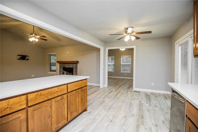 16 Stirling Ln, Bella Vista, AR 72715 - kitchen featuring a ceiling fan, stainless steel dishwasher, a brick fireplace, and light wood finished floors