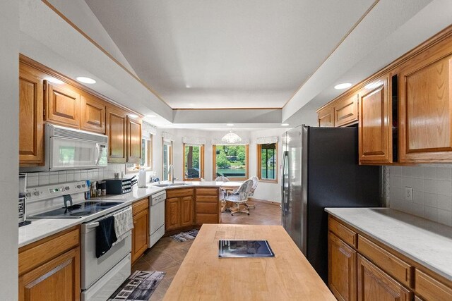 6 Portsmouth Ln, Bella Vista, AR 72715 - kitchen with white appliances, a sink, tasteful backsplash, a peninsula, and a raised ceiling