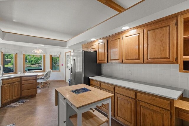 6 Portsmouth Ln, Bella Vista, AR 72715 - kitchen with stainless steel fridge, a sink, decorative backsplash, brown cabinetry, and recessed lighting