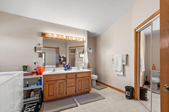 6 Portsmouth Ln, Bella Vista, AR 72715 - bathroom featuring washer and clothes dryer, toilet, double vanity, and baseboards