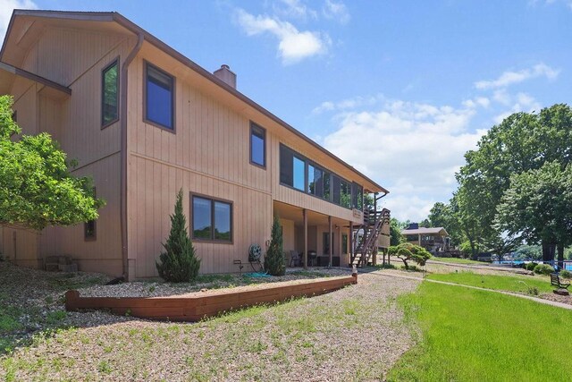 6 Portsmouth Ln, Bella Vista, AR 72715 - view of side of property with stairs, a chimney, and a yard