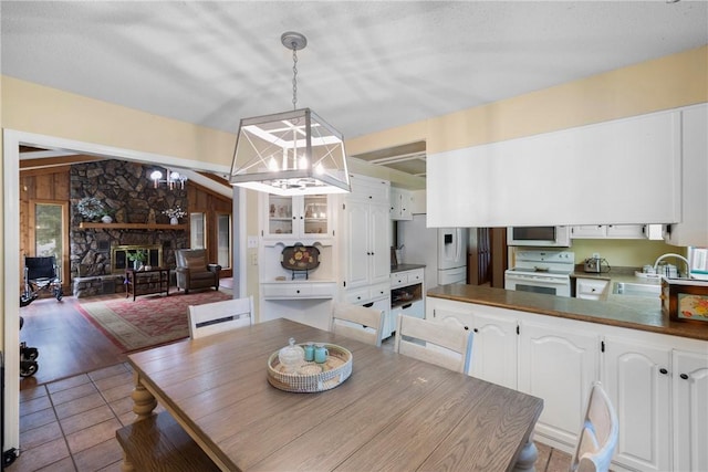 1433 Shalimar Cir, Russellville, AR 72802 - tiled dining area with a sink, a chandelier, and a fireplace