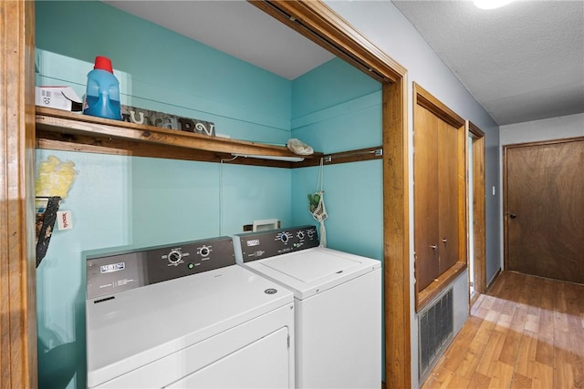 1433 Shalimar Cir, Russellville, AR 72802 - washroom featuring washer and dryer, light wood-style flooring, and a textured ceiling