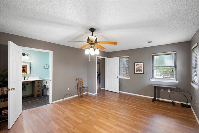 1433 Shalimar Cir, Russellville, AR 72802 - unfurnished bedroom with wood finished floors, a textured ceiling, baseboards, and ceiling fan