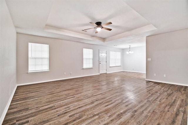 515 Jenkins Rd, Prairie Grove, AR 72753 - spare room featuring a raised ceiling, ceiling fan, a chandelier, dark wood-type flooring, and baseboards