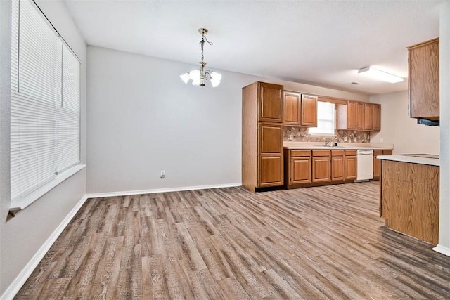 515 Jenkins Rd, Prairie Grove, AR 72753 - kitchen featuring light wood-style flooring, light countertops, decorative backsplash, and a chandelier