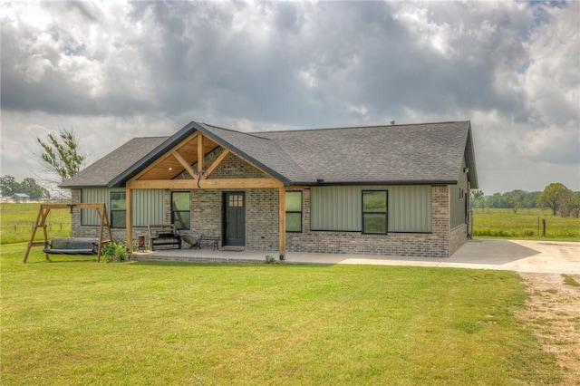13865 State Highway 116, Colcord, OK 74338 - back of house featuring brick siding, a shingled roof, a yard, and board and batten siding