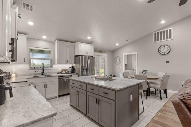 13865 State Highway 116, Colcord, OK 74338 - kitchen featuring stainless steel appliances, a sink, lofted ceiling, a kitchen island, and white cabinets