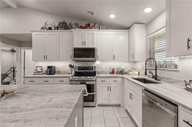 13865 State Highway 116, Colcord, OK 74338 - kitchen with appliances with stainless steel finishes, a sink, vaulted ceiling, white cabinetry, and light tile patterned floors