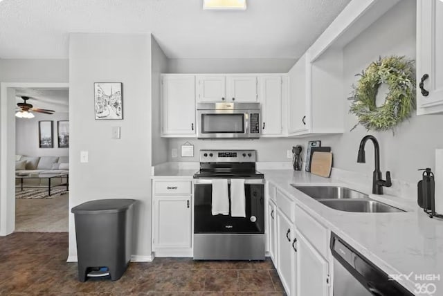1500 Linwood Cir, Bentonville, AR 72712 - kitchen featuring stainless steel appliances, a sink, white cabinetry, a ceiling fan, and a textured ceiling