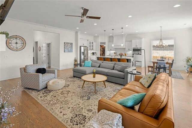 120 Bequette Ln, Centerton, AR 72719 - living room featuring a ceiling fan, light wood-style floors, a chandelier, recessed lighting, and ornamental molding