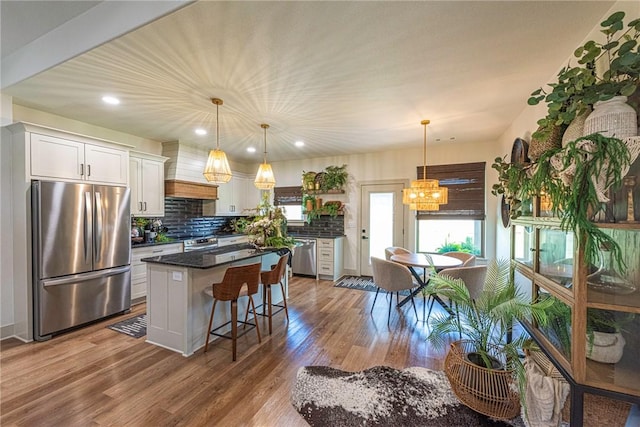 852 Round Top St, Prairie Grove, AR 72753 - kitchen featuring appliances with stainless steel finishes, premium range hood, white cabinets, a kitchen island, and dark wood-style floors