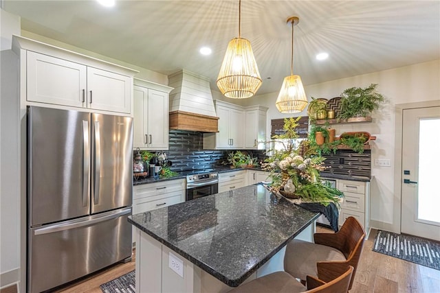 852 Round Top St, Prairie Grove, AR 72753 - kitchen featuring freestanding refrigerator, custom exhaust hood, wood finished floors, decorative backsplash, and a kitchen bar
