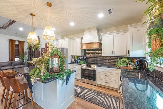852 Round Top St, Prairie Grove, AR 72753 - kitchen featuring custom range hood, stainless steel range with electric cooktop, dark stone counters, a sink, and decorative backsplash