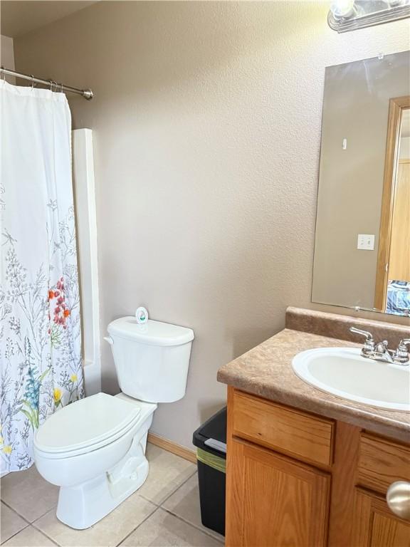 509 SW Persimmon St, Gravette, AR 72736 - full bathroom with tile patterned flooring, toilet, vanity, and a shower with shower curtain