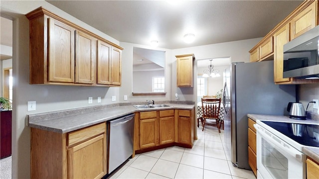 509 SW Persimmon St, Gravette, AR 72736 - kitchen featuring appliances with stainless steel finishes, a sink, light tile patterned flooring, a chandelier, and light countertops
