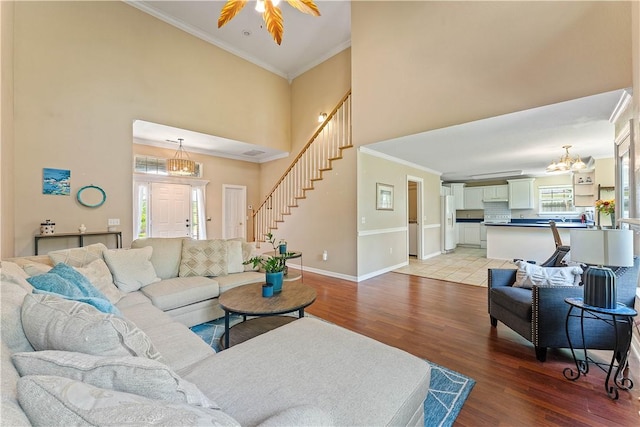4730 Woodside Ln, Springdale, AR 72762 - living area with a chandelier, baseboards, light wood-style flooring, stairway, and a high ceiling