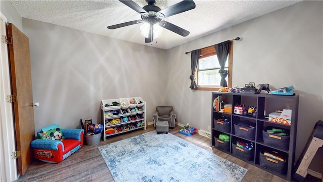 104 NE Deer Ridge Rd, Gravette, AR 72736 - rec room with a textured ceiling, wood finished floors, and ceiling fan