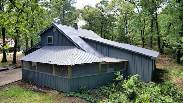 104 NE Deer Ridge Rd, Gravette, AR 72736 - view of side of home featuring metal roof, a chimney, and a sunroom
