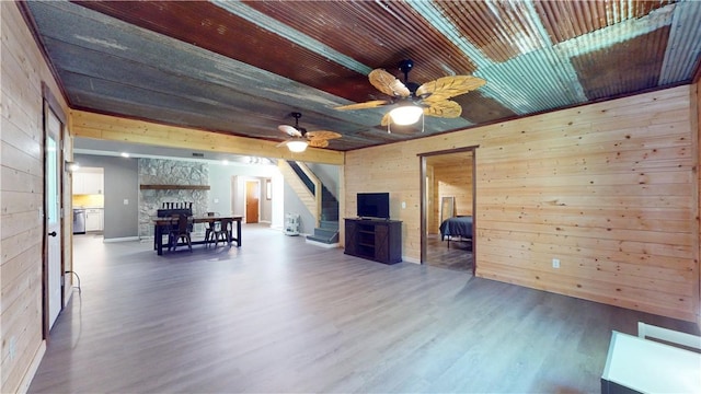 104 NE Deer Ridge Rd, Gravette, AR 72736 - living area featuring wood walls, wood finished floors, stairs, a fireplace, and a ceiling fan