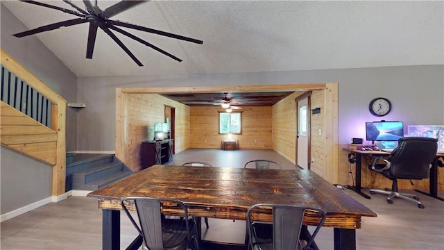 104 NE Deer Ridge Rd, Gravette, AR 72736 - dining area featuring wood walls, wood finished floors, a ceiling fan, stairway, and baseboards