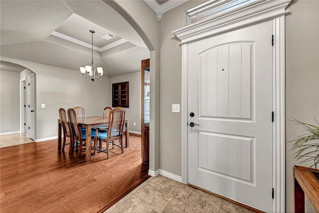 1805 SW Birch St, Bentonville, AR 72713 - foyer featuring arched walkways, a raised ceiling, a chandelier, crown molding, and baseboards