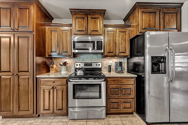 1805 SW Birch St, Bentonville, AR 72713 - kitchen with stainless steel appliances, backsplash, light stone countertops, a textured ceiling, and brown cabinetry