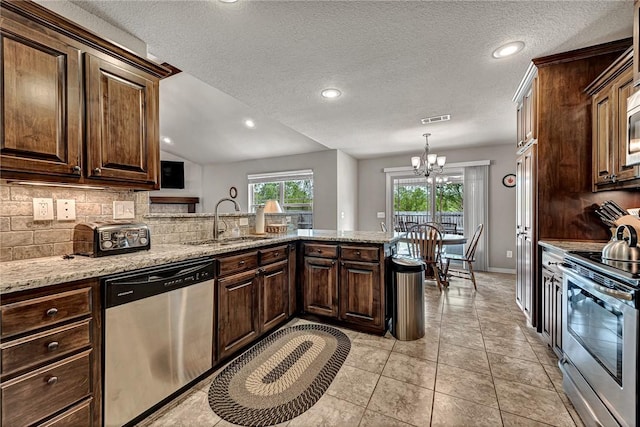 1805 SW Birch St, Bentonville, AR 72713 - kitchen with appliances with stainless steel finishes, a sink, a chandelier, decorative backsplash, and a peninsula