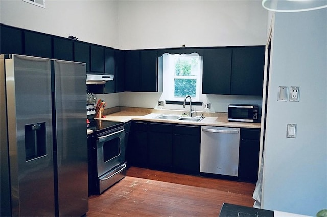 1211 N Mission Blvd, Fayetteville, AR 72701 - kitchen featuring stainless steel appliances, under cabinet range hood, dark wood-style floors, and light countertops