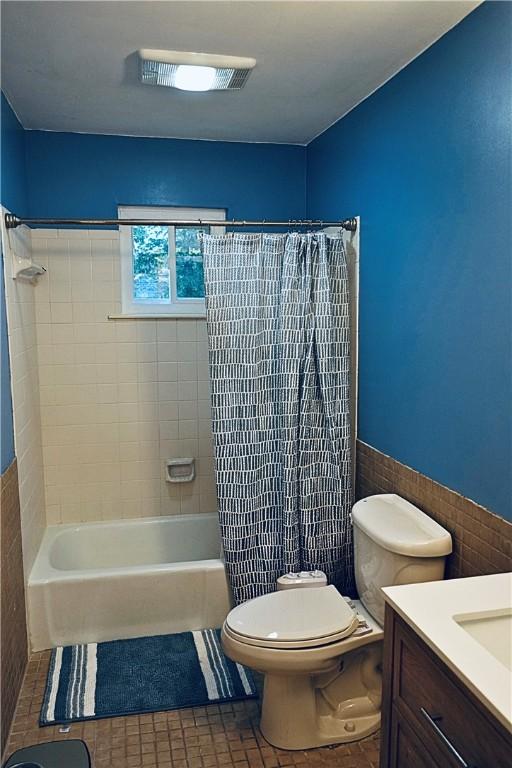 1211 N Mission Blvd, Fayetteville, AR 72701 - bathroom with vanity, shower / tub combo, tile walls, wainscoting, and tile patterned floors