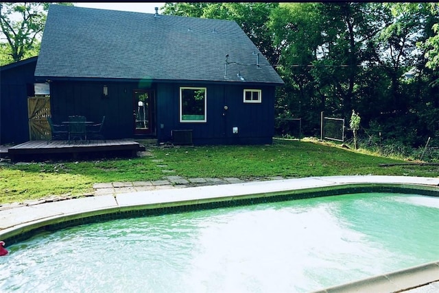 1211 N Mission Blvd, Fayetteville, AR 72701 - rear view of property featuring a wooden deck, an outdoor pool, a shingled roof, and a lawn