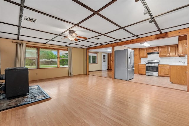 12549 Little Elm Rd, Farmington, AR 72730 - unfurnished living room with a wood stove, light wood-type flooring, a ceiling fan, and a sink