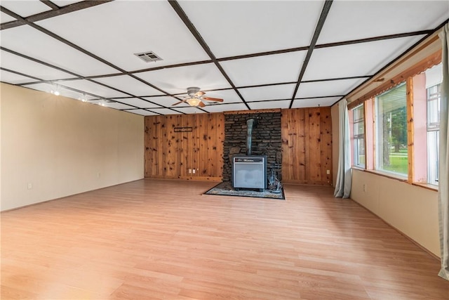 12549 Little Elm Rd, Farmington, AR 72730 - unfurnished living room with a wood stove, wooden walls, and light wood-type flooring