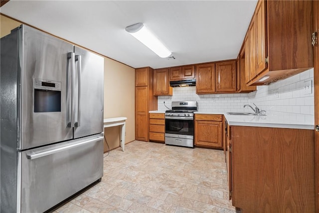 12549 Little Elm Rd, Farmington, AR 72730 - kitchen with stainless steel appliances, under cabinet range hood, a sink, brown cabinets, and decorative backsplash