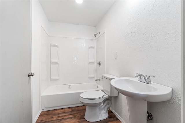 12549 Little Elm Rd, Farmington, AR 72730 - bathroom featuring wood finished floors, toilet, a textured wall, and tub / shower combination