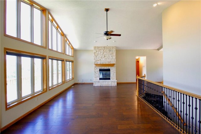 70 Shields Spur, Holiday Island, AR 72631 - unfurnished living room featuring ceiling fan, hardwood / wood-style flooring, baseboards, high vaulted ceiling, and a fireplace
