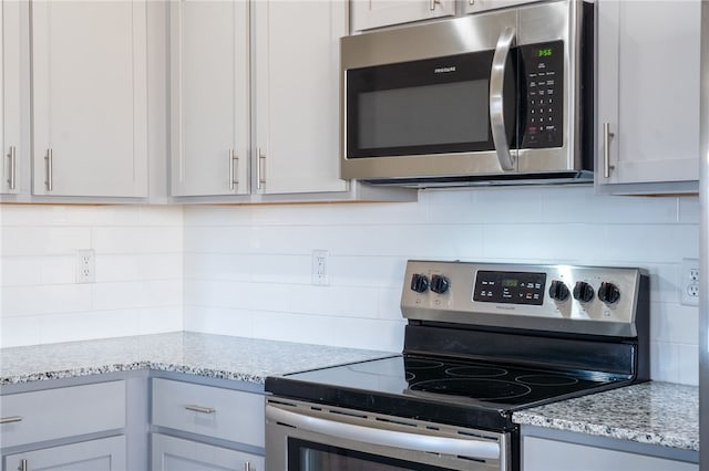 2405 Maplewood Ave, Lowell, AR 72745 - kitchen featuring stainless steel appliances, tasteful backsplash, and light stone countertops
