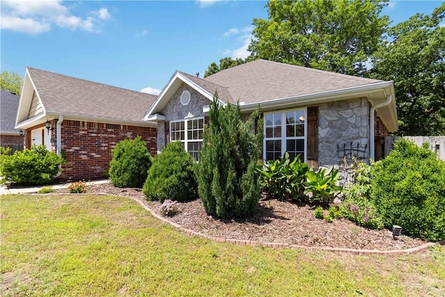 603 Highland Ct, Siloam Springs, AR 72761 - view of front of home with a front yard, stone siding, a shingled roof, and brick siding