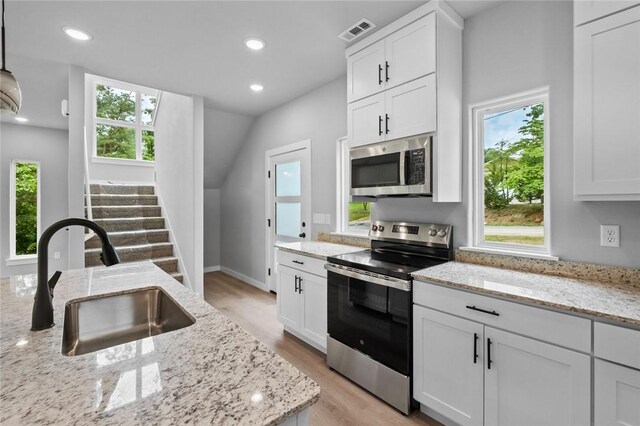 2 Brightling Ln, Bella Vista, AR 72715 - kitchen featuring appliances with stainless steel finishes, a sink, light wood-style flooring, white cabinetry, and light stone counters