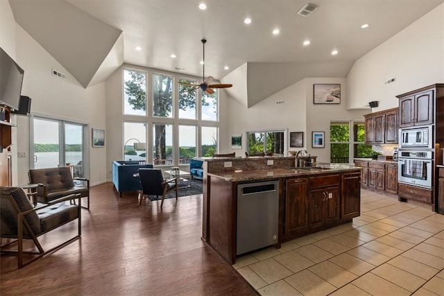 15100 Railroad Cut Rd, Rogers, AR 72756 - kitchen with stainless steel appliances, a sink, high vaulted ceiling, a kitchen island with sink, and open floor plan