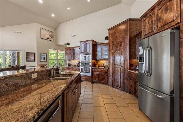 15100 Railroad Cut Rd, Rogers, AR 72756 - kitchen featuring appliances with stainless steel finishes, a sink, high vaulted ceiling, light tile patterned floors, and dark stone countertops