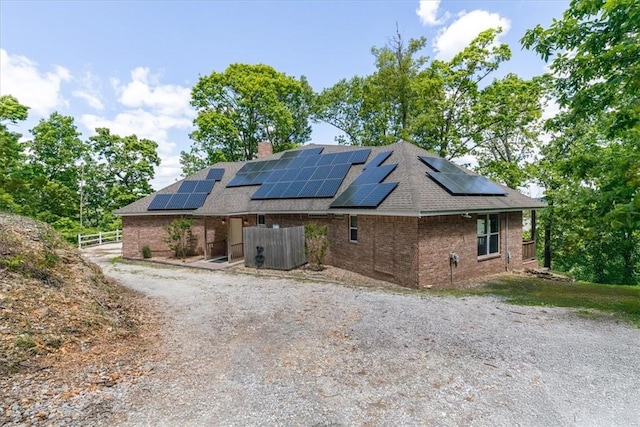 15100 Railroad Cut Rd, Rogers, AR 72756 - view of front of property with brick siding, solar panels, roof with shingles, and a chimney
