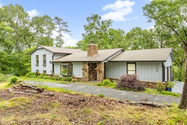 17934 Timberlake Trl, Rogers, AR 72756 - view of front of home featuring stone siding, a chimney, a garage, and roof with shingles