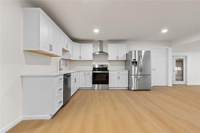 3916 O Street Ter, Harrison, AR 72601 - kitchen with appliances with stainless steel finishes, wall chimney exhaust hood, a sink, light wood-type flooring, and white cabinets