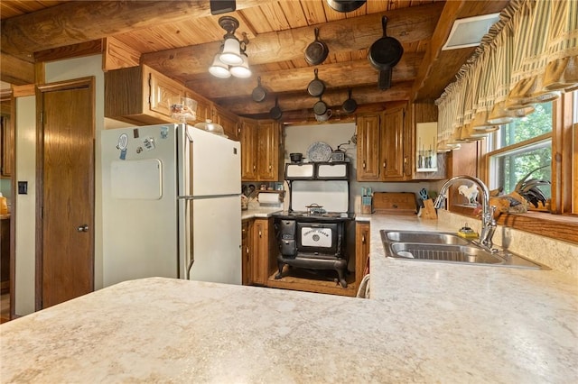 5287 Forgeson Rd, Harrison, AR 72601 - kitchen with freestanding refrigerator, a sink, light countertops, wooden ceiling with exposed beams, and brown cabinets